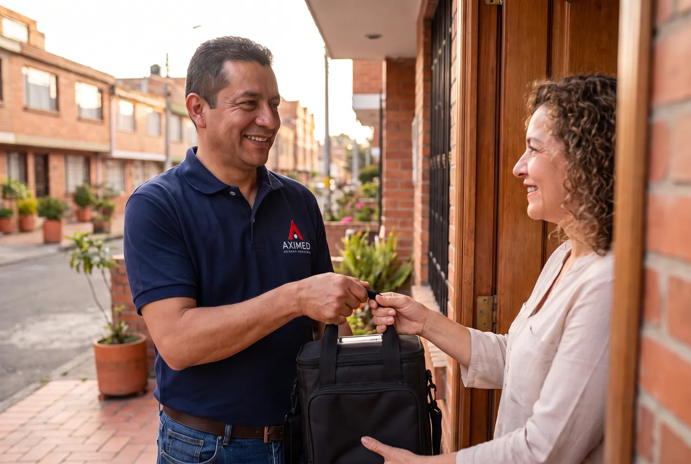 Técnico con uniforme de AXIMED entregando un equipo en una casa