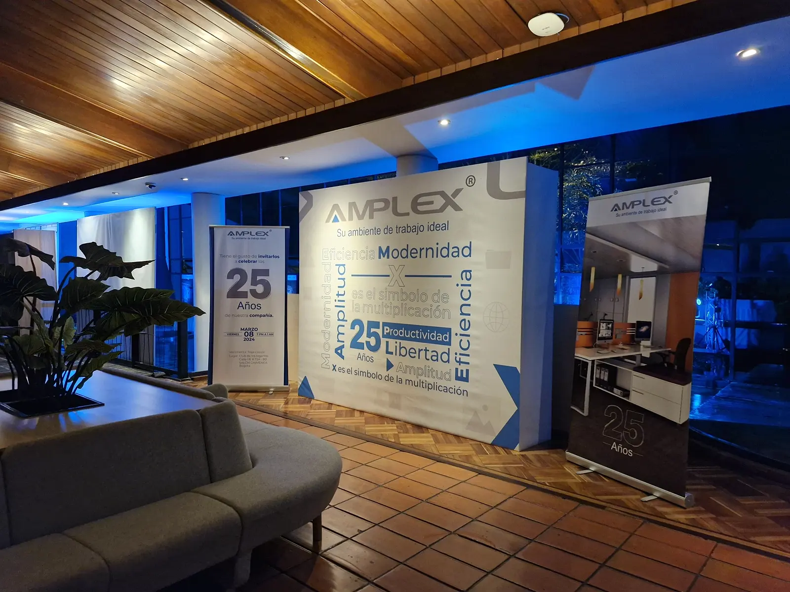 Backing de los 25 años de Amplex con roll-ups e iluminación azul