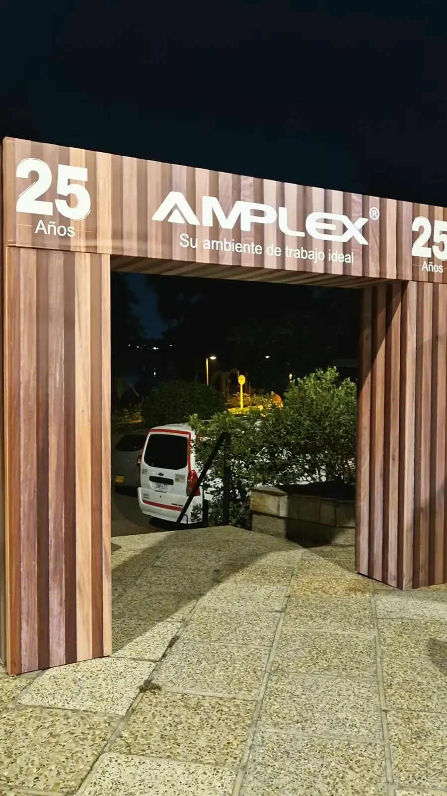 Arco de ingreso con acabado tipo madera y la marca Amplex 25 años