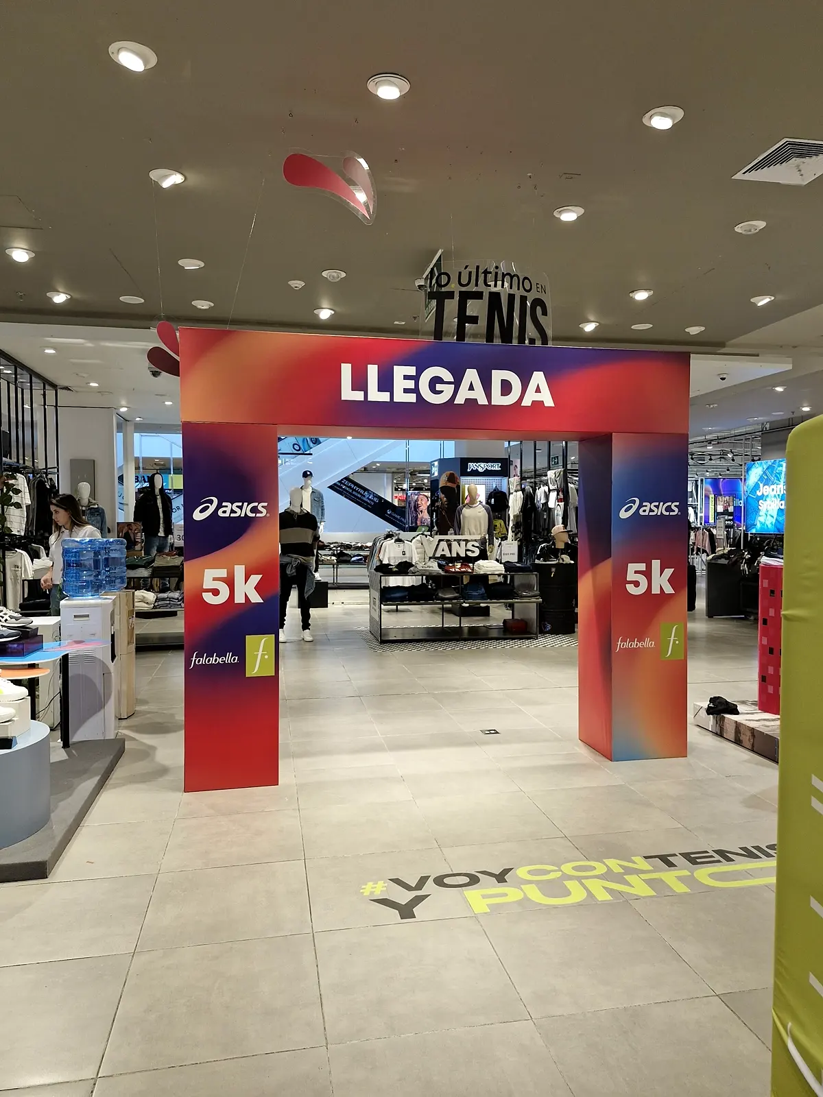 Arco de llegada Asics 5K con la palabra LLEGADA y logos de Falabella a la entrada de la tienda Falabella en C. C. Colina
