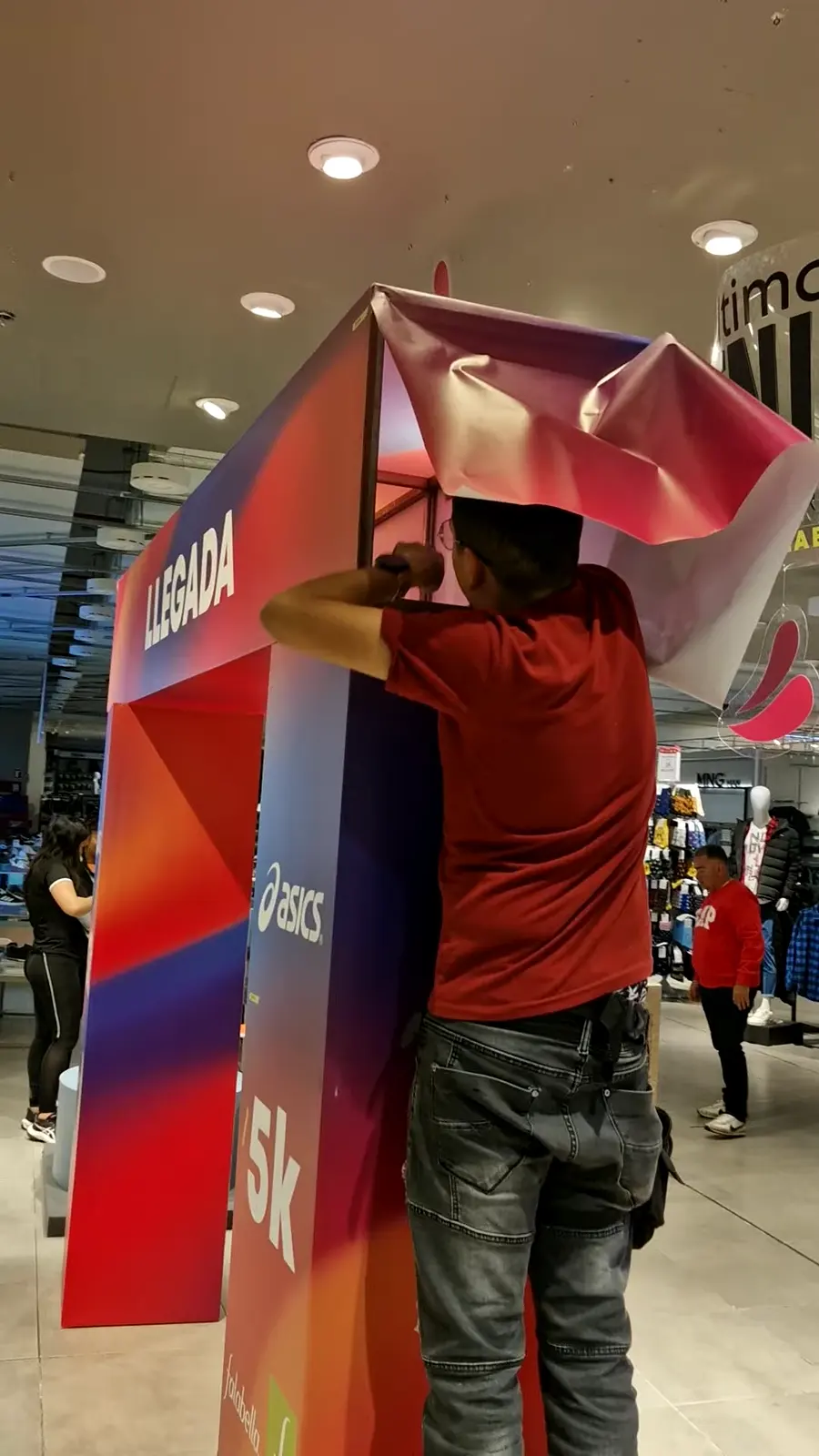 Instalador forrando la estructura del arco con la impresión dentro de la tienda Falabella