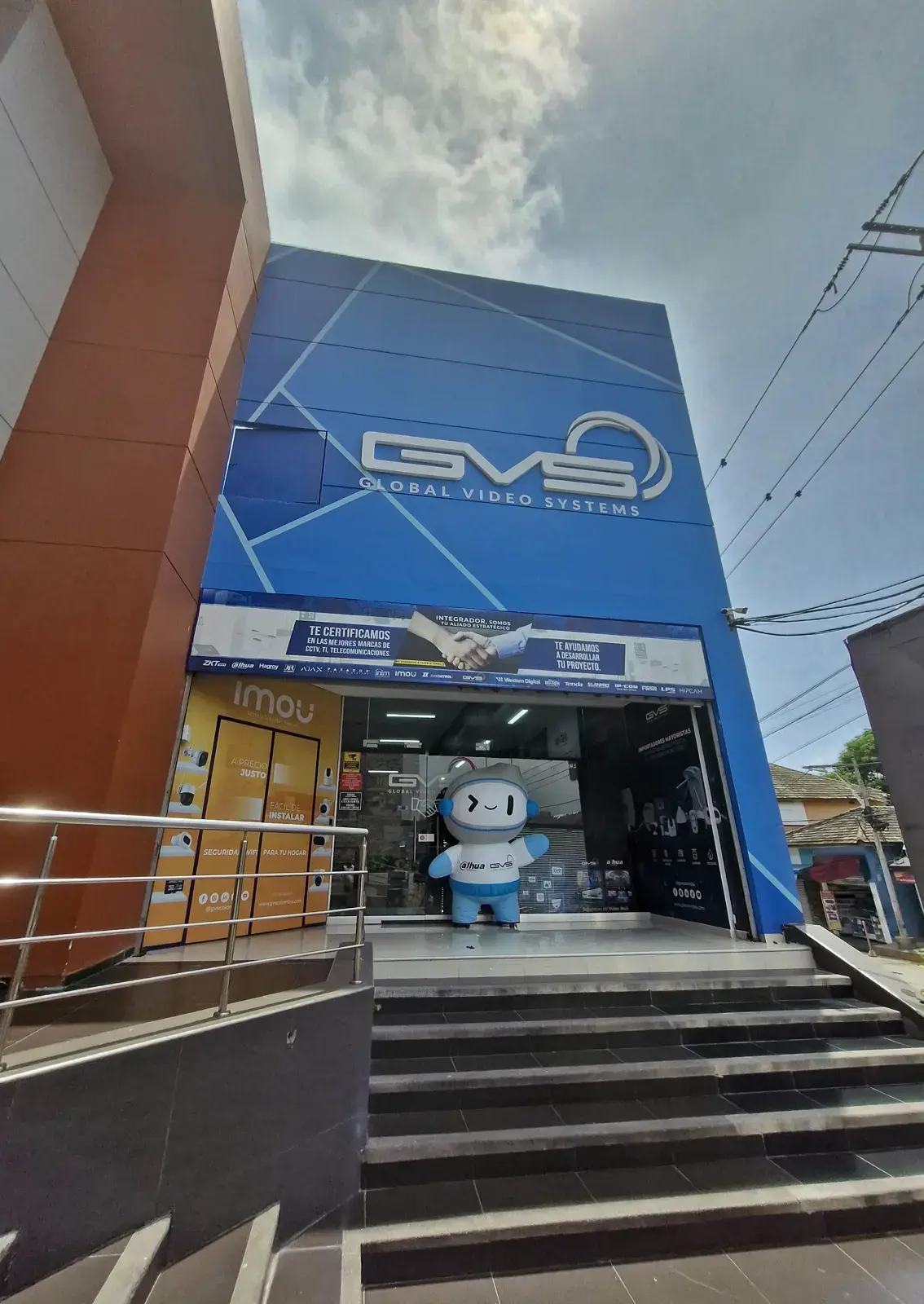 Entrada de la sede GVS en Barranquilla con el aviso GVS en la fachada azul y el pendón superior sobre la puerta