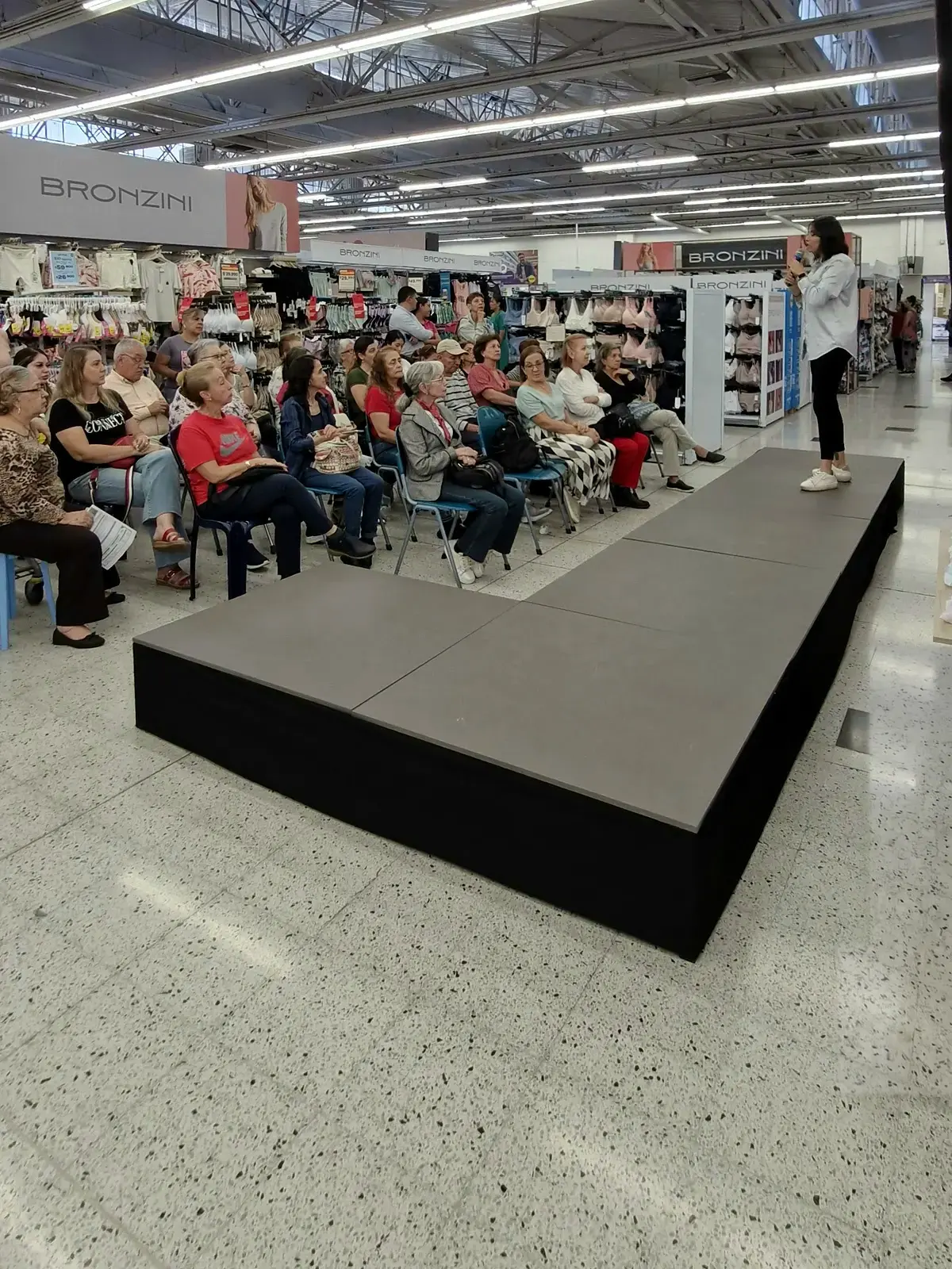 Presentadora sobre la pasarela en L frente al público durante el conversatorio de Lilipink en Medellín