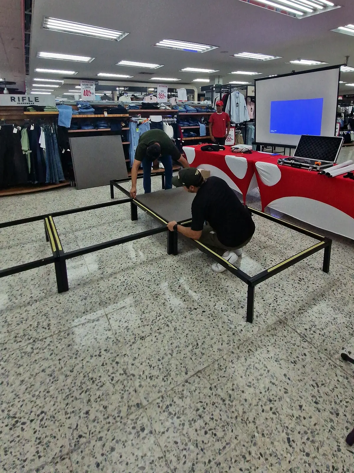 Montajistas armando la estructura metálica de la pasarela antes de poner las tapas, en un almacén de Barranquilla